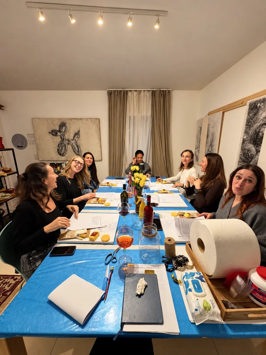 Un piccolo gruppo di adulte riunito intorno al tavolo durante un Aperitivo con DAMA